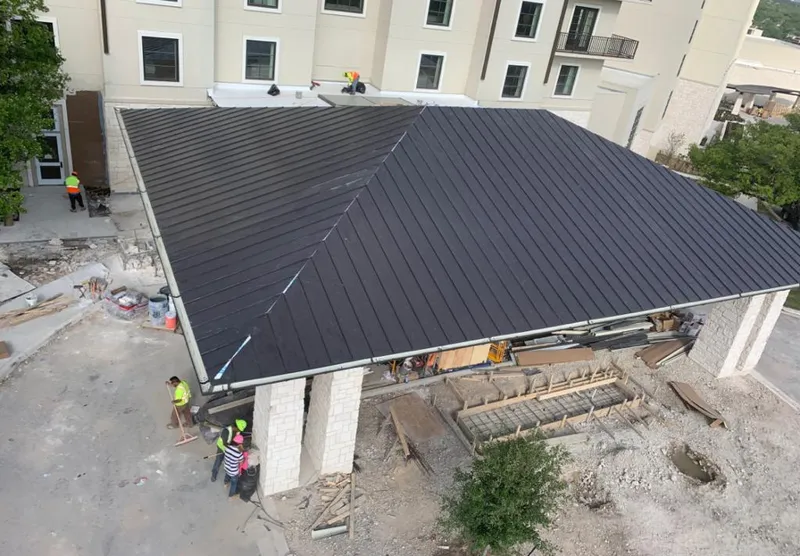 Metal roofing installation team working on a commercial building in Garrett